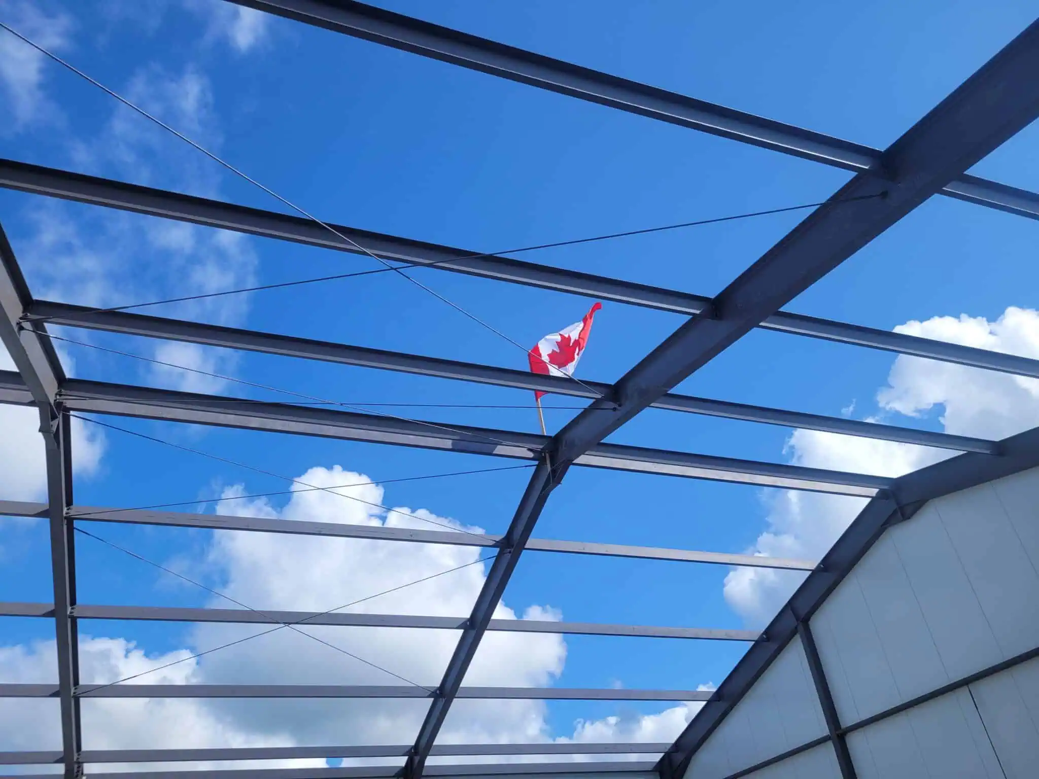 Maxspan steel frame project under construction beneath a Canadian flag